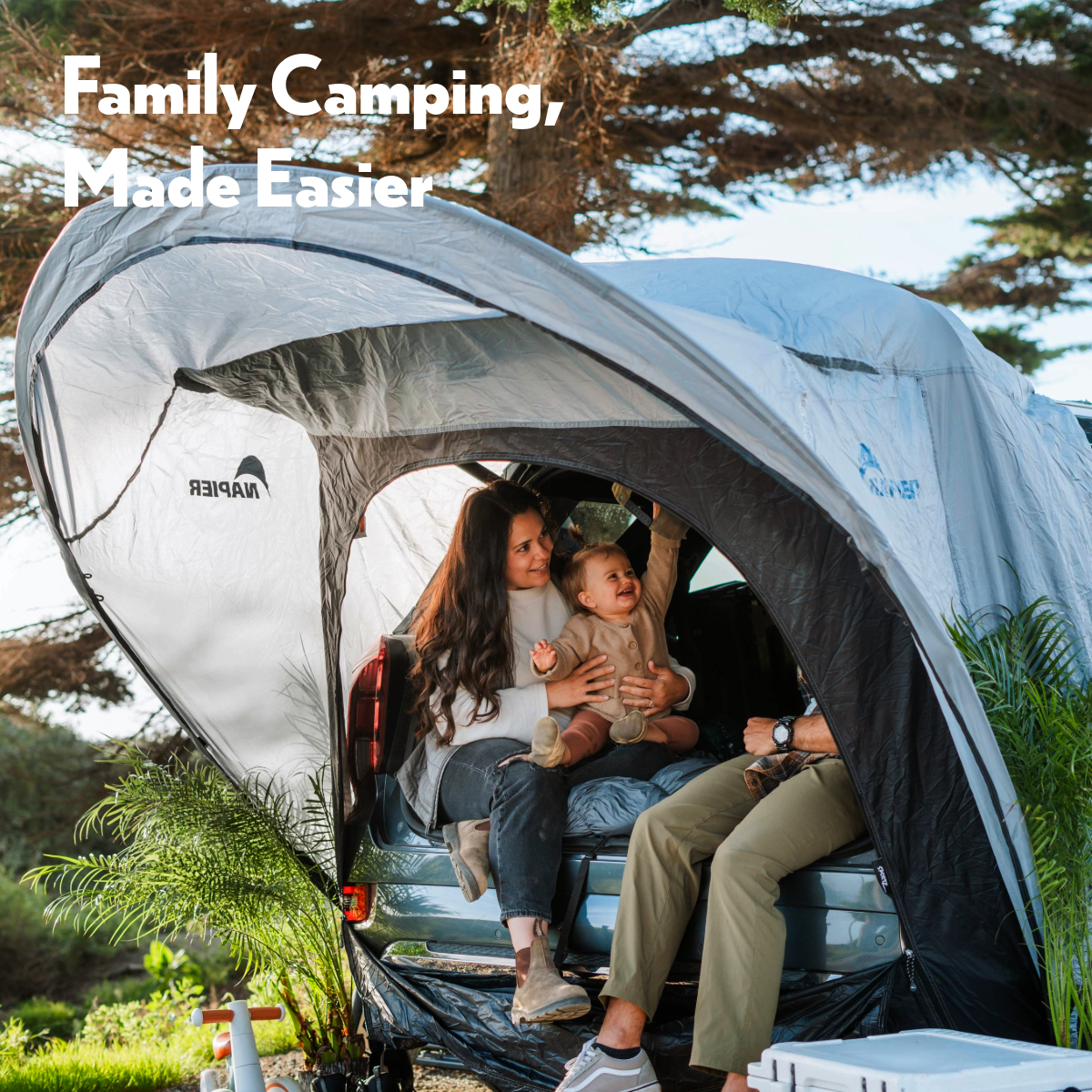 Family using Backroadz SUV tent for car camping with kids at lakeside campsite.
