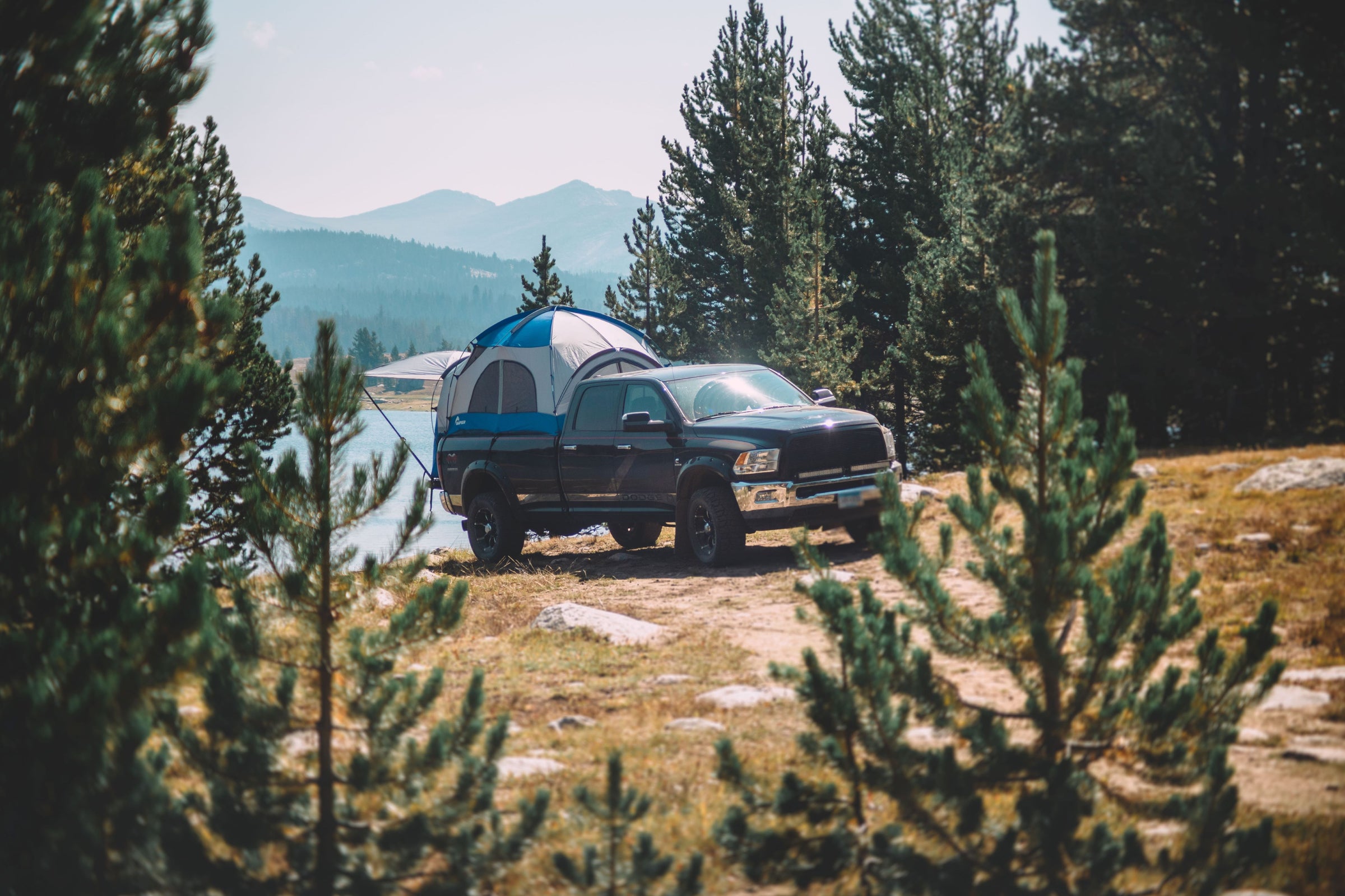 Napier truck tent overlanding camping set up next to the lake