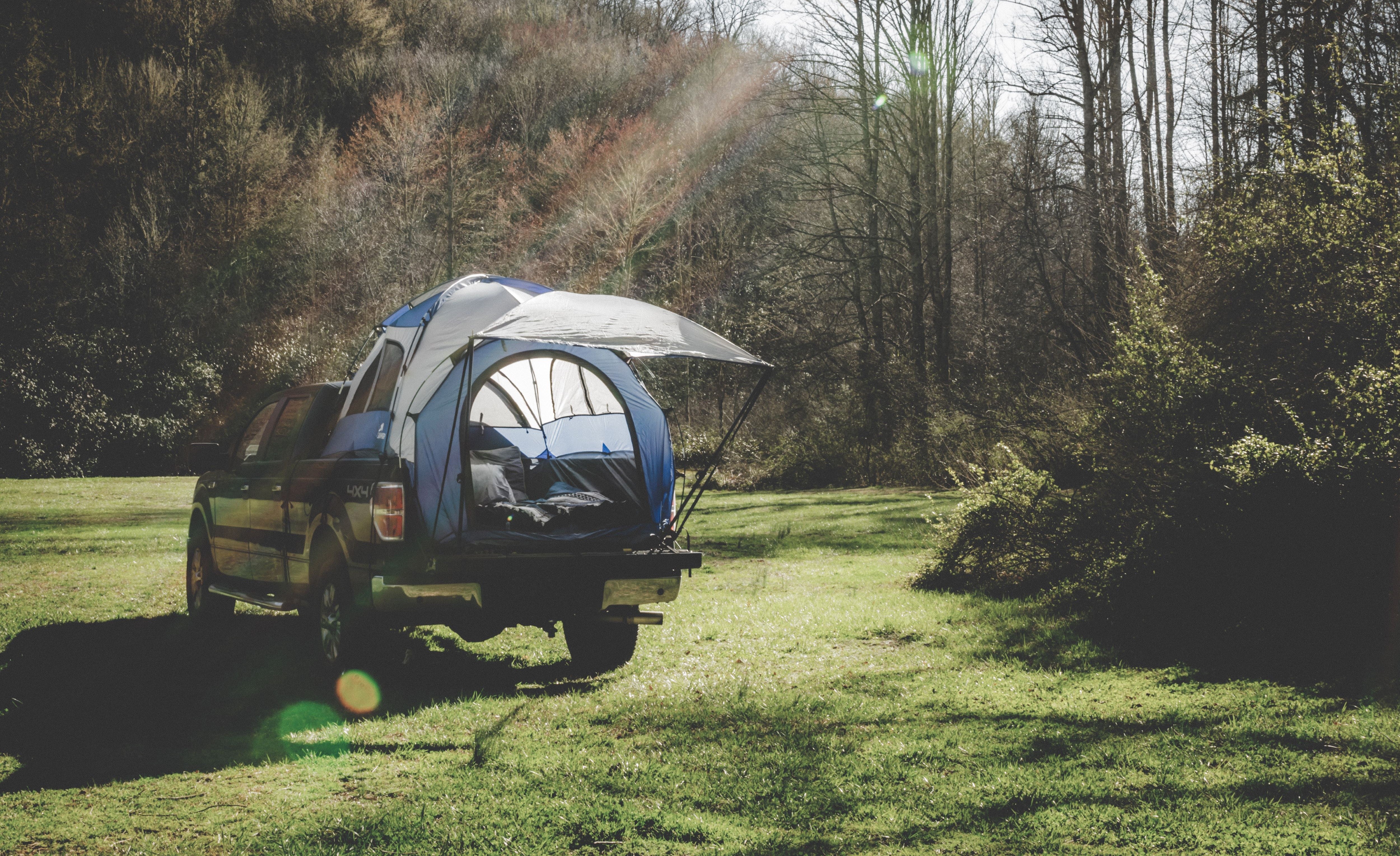 Napier truck tent camping overlanding set up in the forest