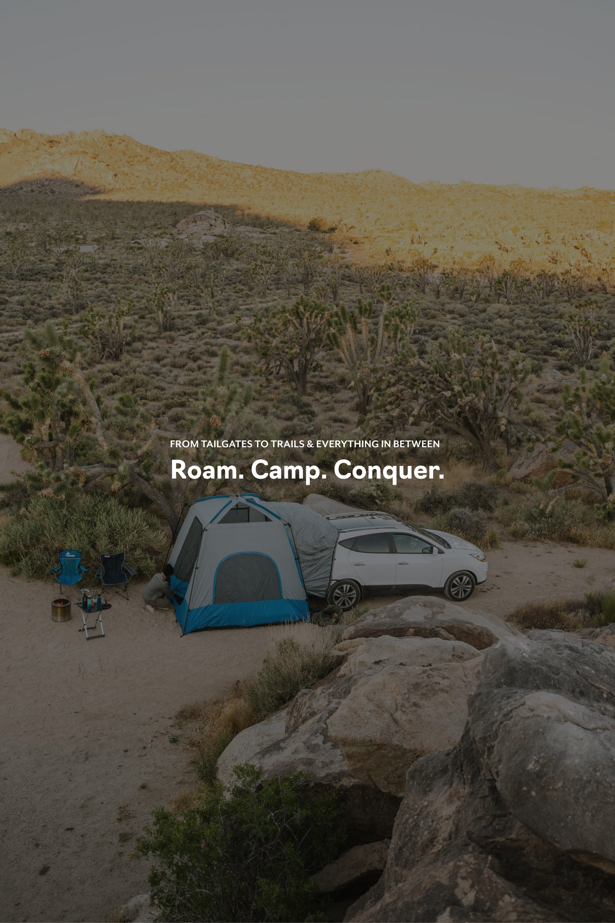 Car with SUV tent overlanding camping set up in the desert with text "roam.camp.conquer."