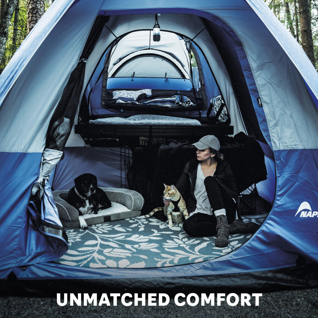 girl and dog sitting inside a napier link tent attachment to a truck tent