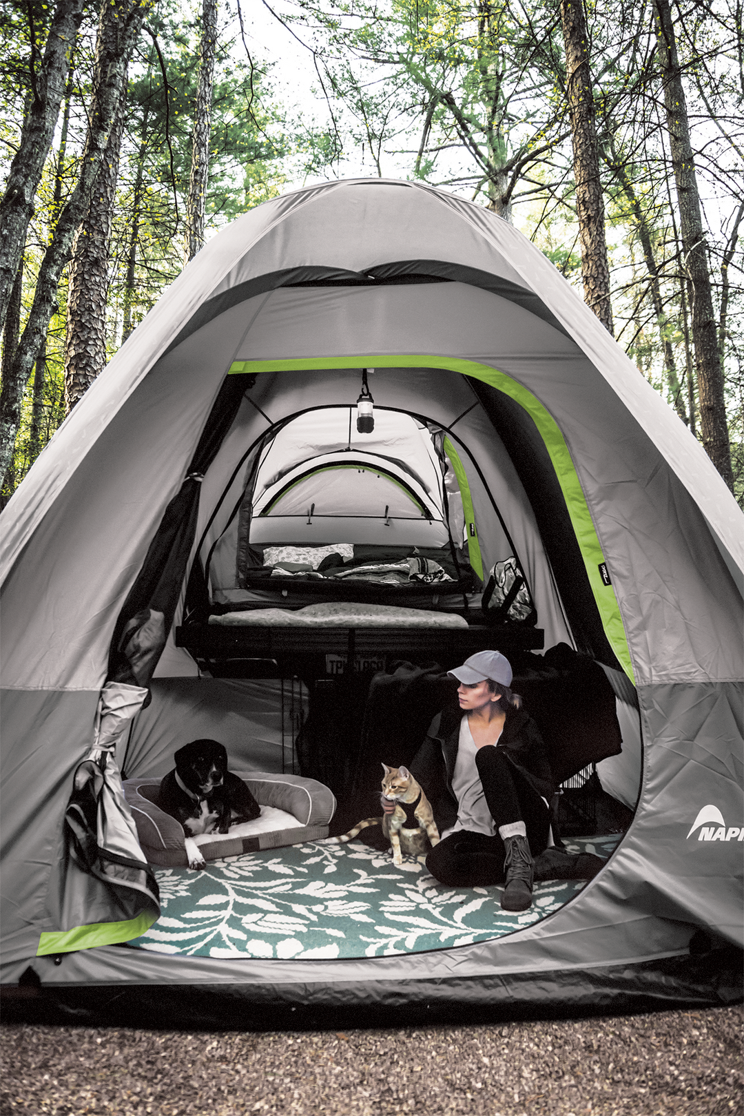 girl and dog sitting inside a truck tent and link ground attchment camping set up 