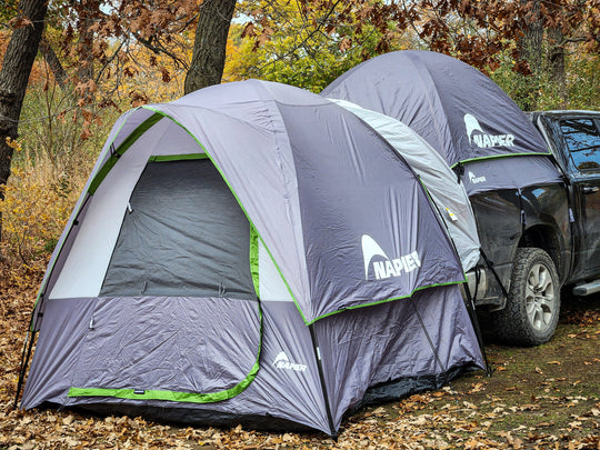 napier outdoors grey truck tent and ground tent link attachment on a truck in the forest