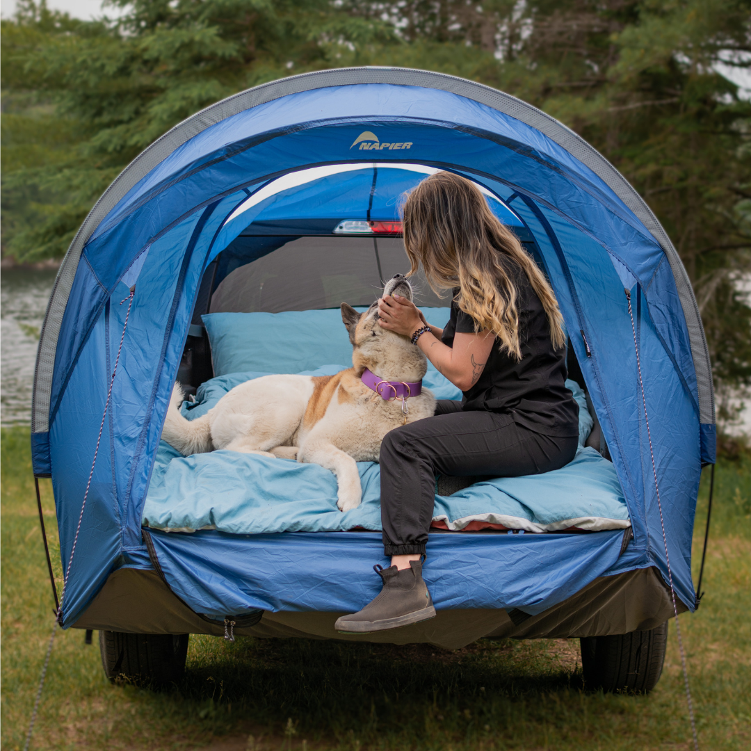 Woman and dog inside a napier outdoors maverick truck tent