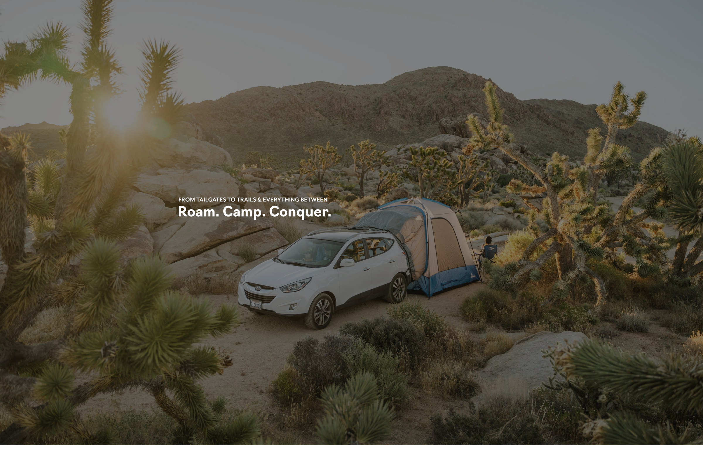 Car with SUV tent overlanding camping set up in the desert with text "roam.camp.conquer."