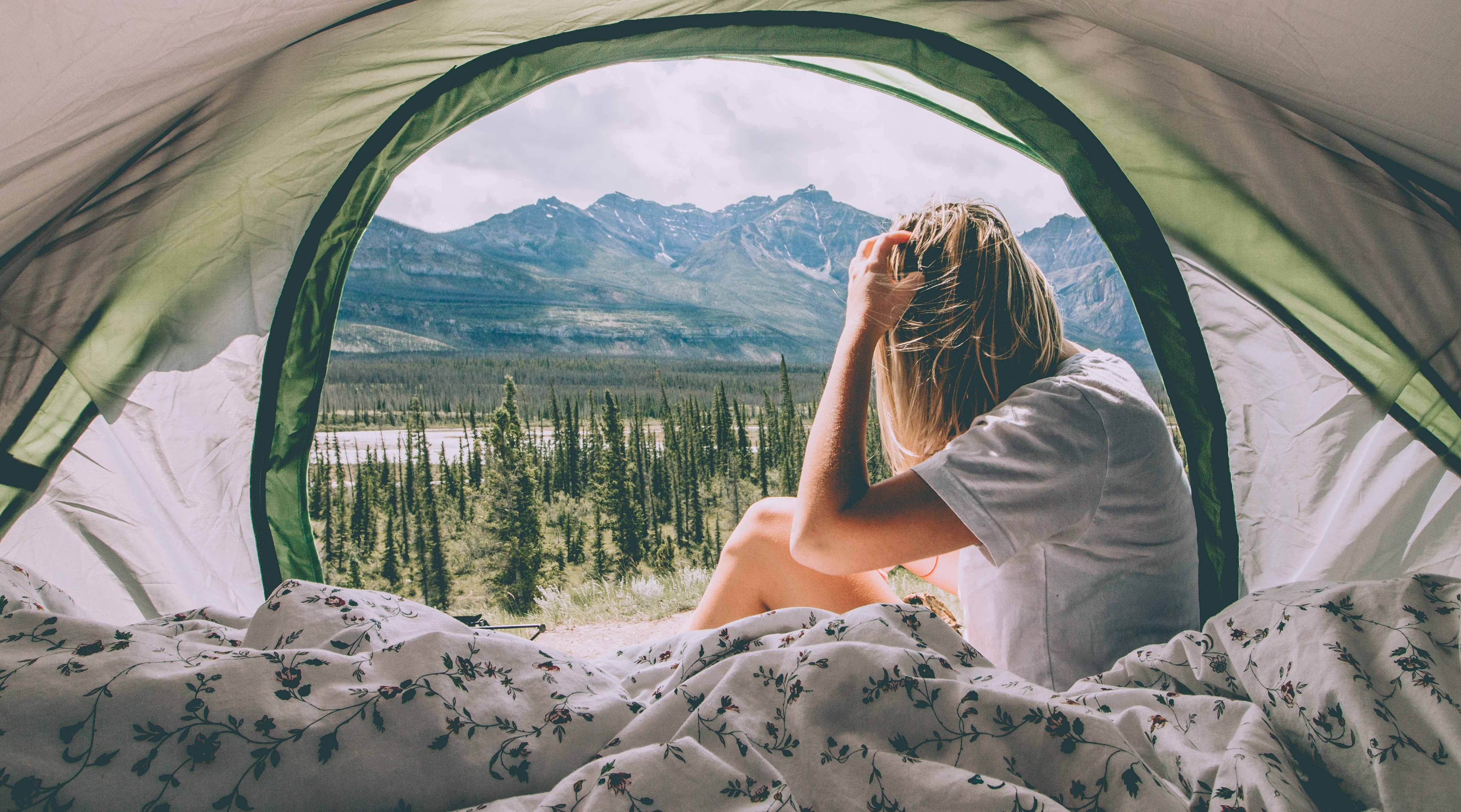 girl sitting inside a napier truck bed tent set up overlooking the mountains