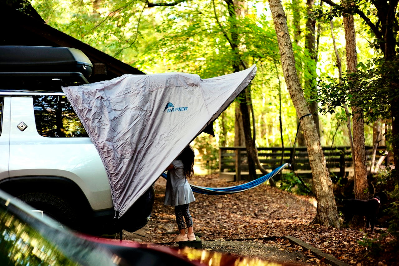 child standing in a vehicle awning tent