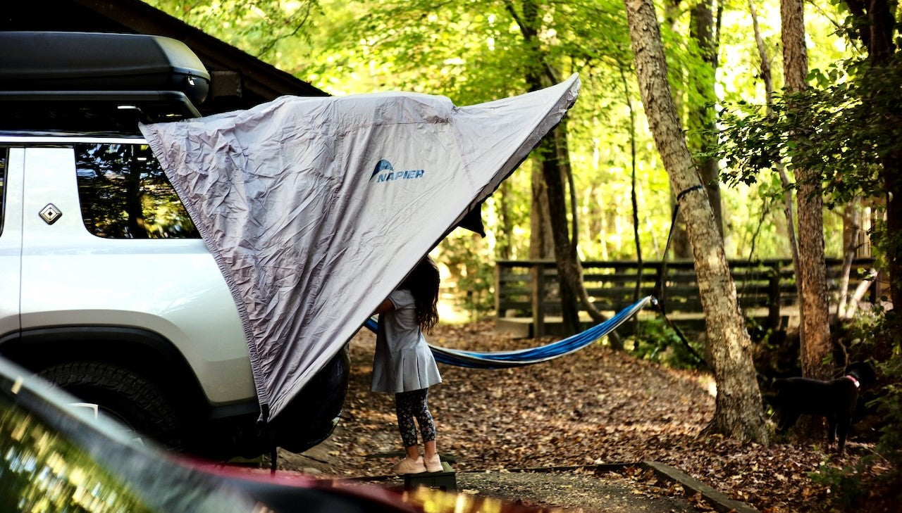 Child standing inside the napier sportz cove awning tent for cars and suv